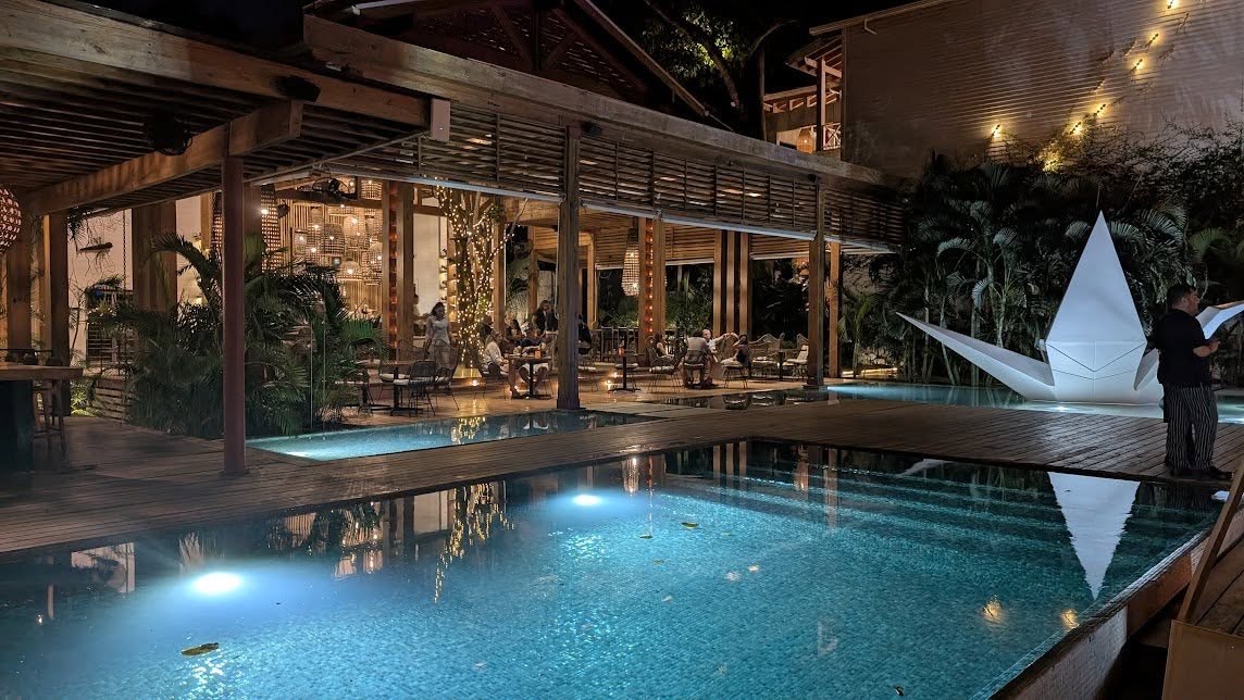 A stylish restaurant scene at Luna Muna by Ibagari with poolside seating and warm lighting.