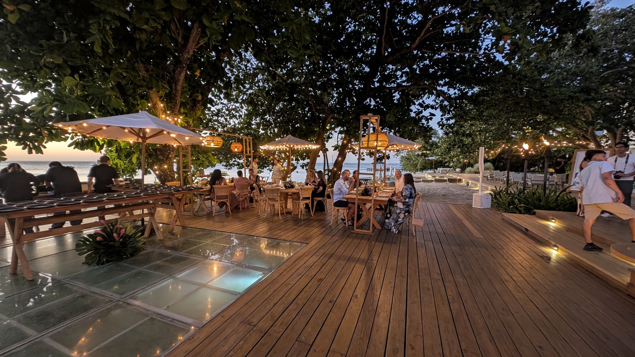 Outdoor dining area with string lights and wooden deck.