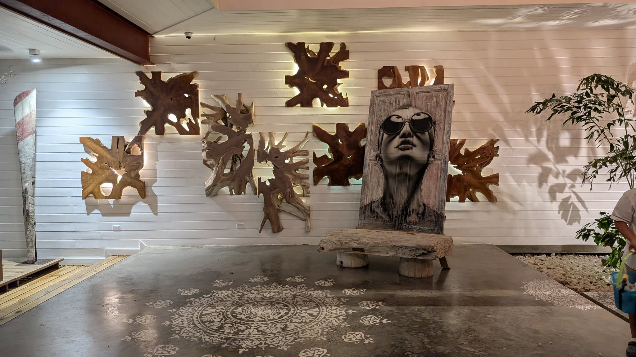 Art installation featuring a portrait and wooden sculptures at Luna Muna by Ibagari.