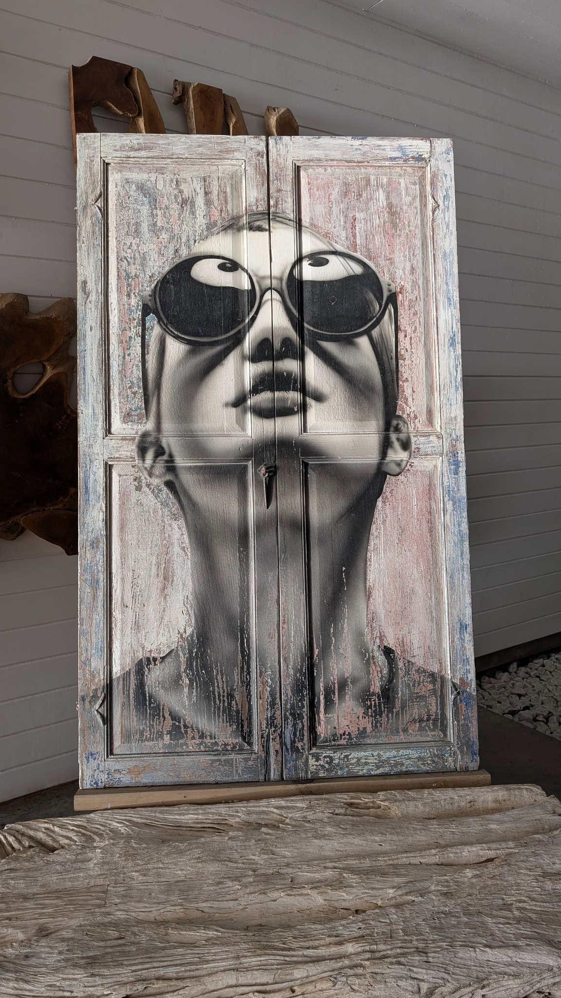 Colorful graffiti mural of a woman wearing sunglasses on wooden doors.