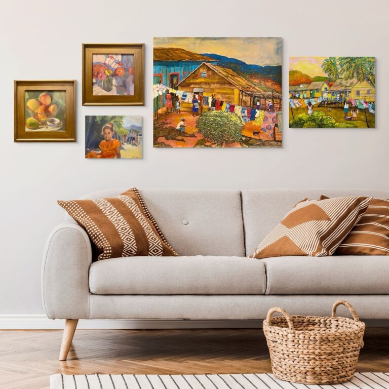 Gallery wall in a living room with five colorful paintings depicting scenes and items from Roatan, Honduras, including local village life, landscapes, and fruit still life.
