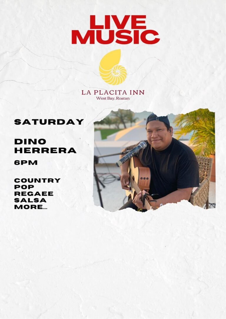 A young man with a hat playing an acoustic guitar during a live music performance at La Placita Inn in West Bay, Roatan, Honduras, with tropical plants in the background.
