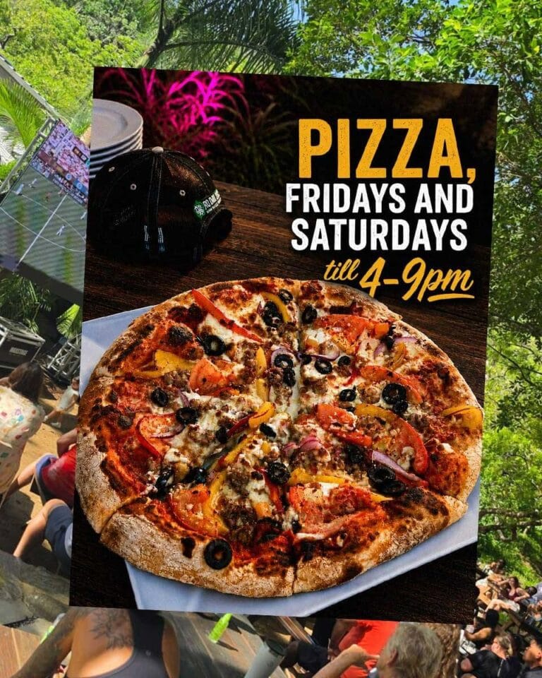 A promotional poster for a Roatan restaurant advertising pizza specials on Fridays and Saturdays until 9 pm, featuring a close-up of a freshly baked pizza topped with colorful vegetables and black olives, with a dark background and the text prominently displayed.