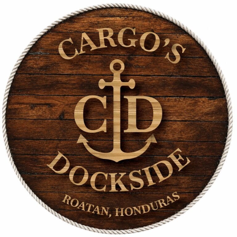 A round wooden sign with a white rope border displaying an anchor and the words 'Cargo's Dockside Roatan Honduras' engraved on the dark stained wood surface.