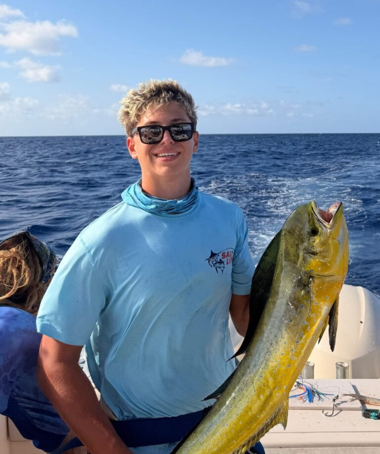 Angler holds a large golden mahi-mahi aboard a boat off Roatan, Honduras.