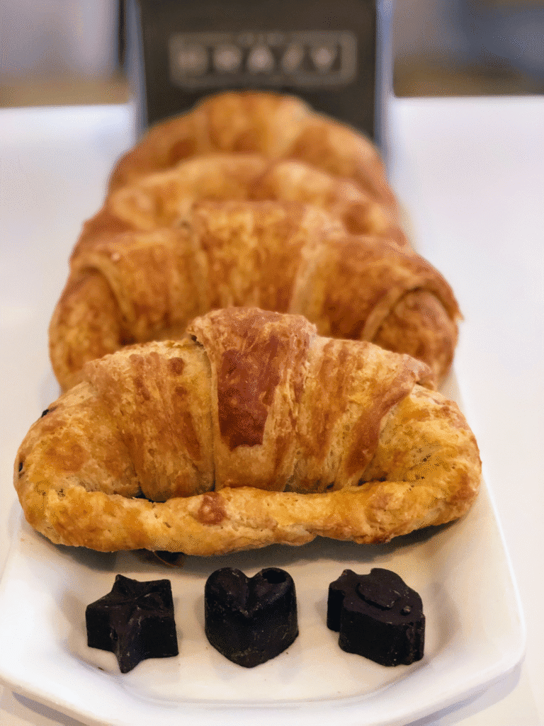 Fried empanadas with black candies are displayed on a white plate in this image from Roatan, Honduras.