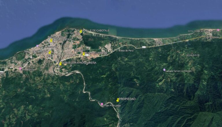 Satellite map of Roatan, Honduras, showing the northern coastline, main road, and surrounding lush green forest with labeled points of interest including hotels, landmarks, and local businesses.