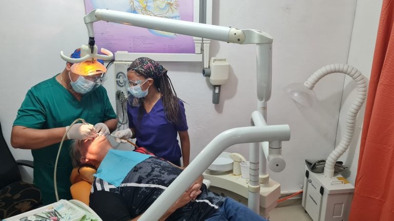 Dental professionals are performing a dental procedure on a patient in a clinic located in Roatan, Honduras.