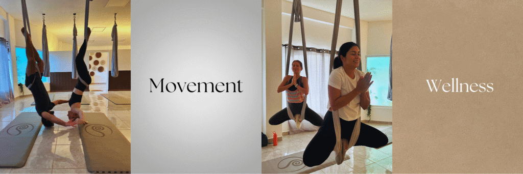 Two women practicing aerial yoga with fabric hammocks indoors in Roatan, Honduras, surrounded by natural light and neutral-colored walls, with the words "Movement" and "Wellness" overlaid on the image.