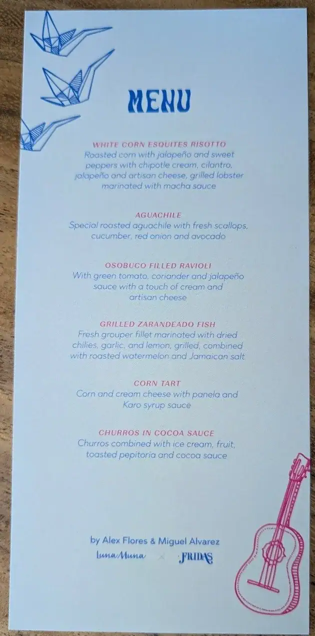 A printed restaurant menu featuring Honduran and Roatan-inspired dishes, with blue origami-style paper cranes in the top left corner and a pink outline illustration of a guitar in the bottom right corner.