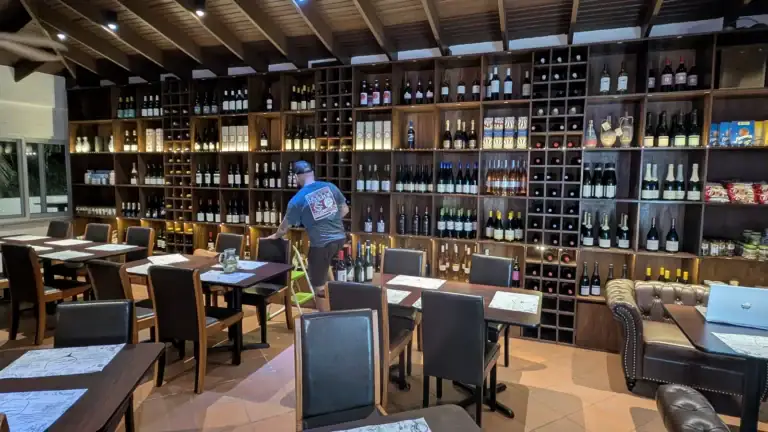 Wine Not wine bar interior in French Harbour with full wine wall, tables, and leather seating
