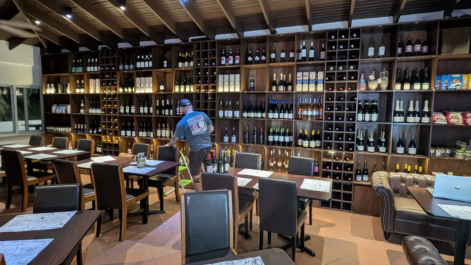 Wine Not wine bar interior in French Harbour with full wine wall, tables, and leather seating