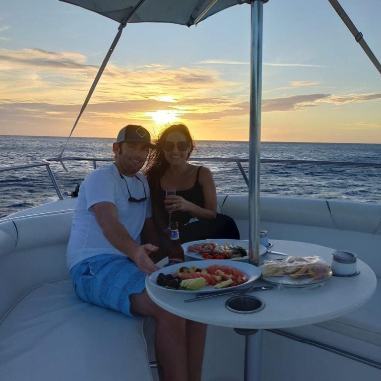 Enjoying a sunset aboard a boat with friends, featuring snacks and drinks in Roatan.