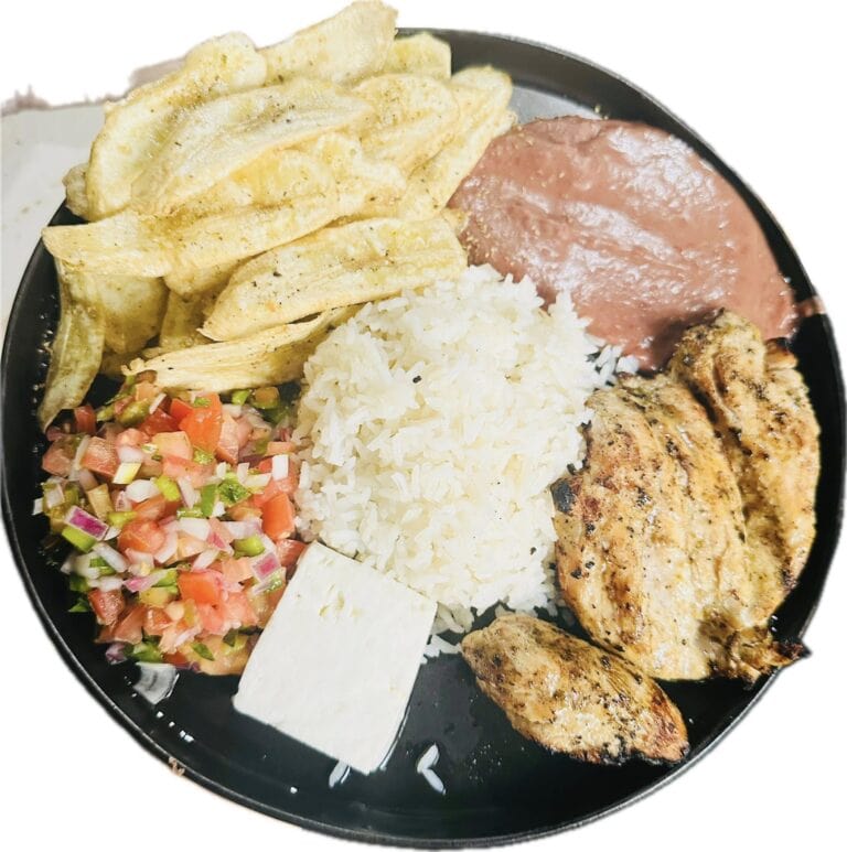A black plate on Roatan in Honduras contains grilled chicken, white rice, a slice of ham, French fries, and a colorful vegetable salsa.