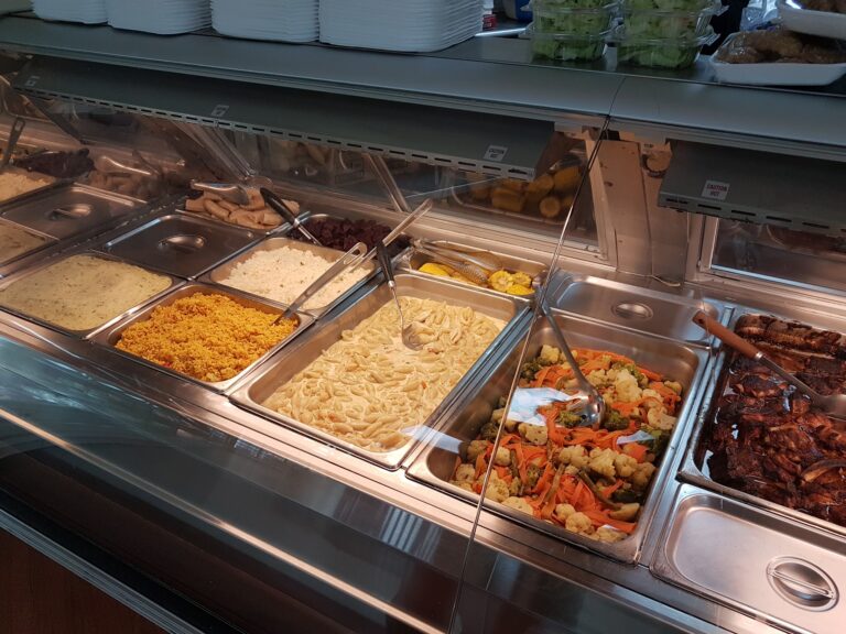 A buffet station with various prepared dishes and salads, set up in a restaurant or food service area on Roatan, Honduras.