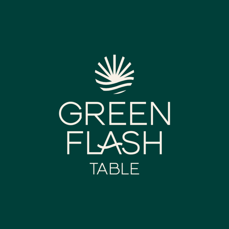 A dark green background features the logo of Green Flash Table, with a stylized sun and waves icon above the text, representing a business in Roatan, Honduras.