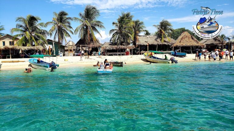 A busy beachfront scene in Roatan, Honduras, featuring boats near the sandy shore, palm trees, and thatched-roof structures with people enjoying the sunny day and water activities.