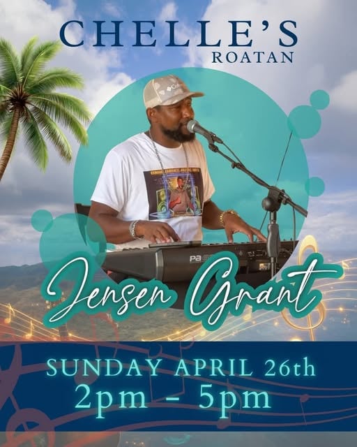 A performer plays a keyboard and sings into a microphone in front of a backdrop promoting a musical event at Chelle's in Roatan, Honduras, with tropical palm trees and a bright sky surrounding him.
