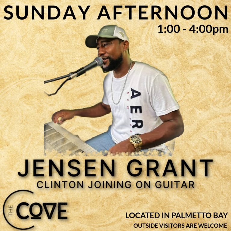 A musician performs live on Roatan in Honduras at The Cove, singing into a microphone while playing a keyboard, with a promotional poster for a Sunday afternoon concert featuring Jensen Grant and Clinton in Palmetto Bay.