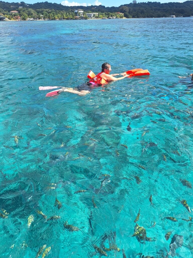 Snorkeler exploring vibrant marine life in Roatan's turquoise waters.