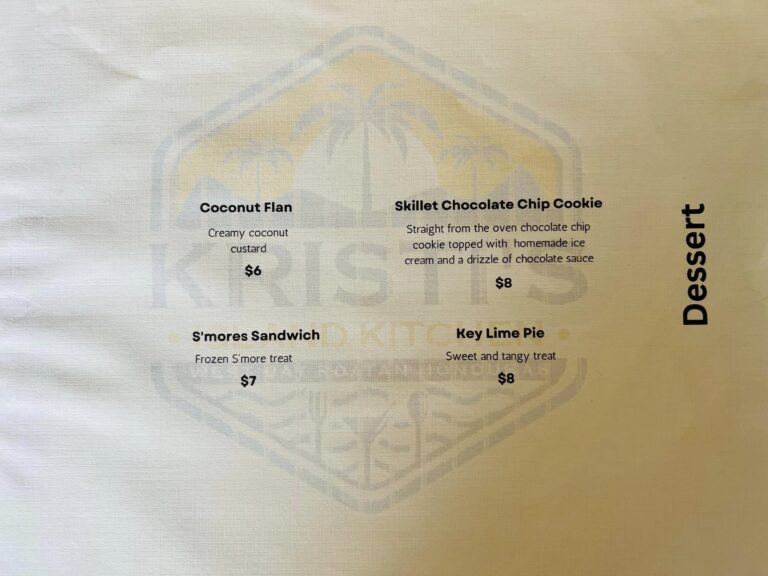 A menu showcasing various desserts in a cozy café located in Roatan, Bay Islands, Honduras, including coconut flan and akinson chocolate chip cookie with detailed descriptions.