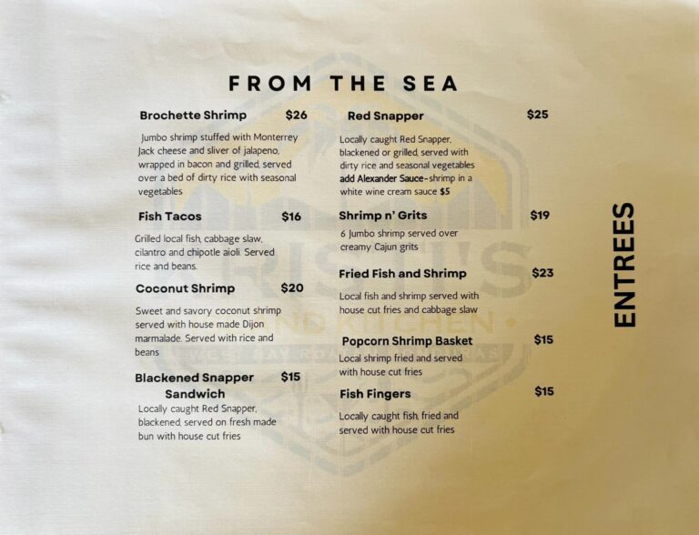 Close-up of a printed menu featuring seafood dishes from Roatan Honduras, including shrimp, fish, and shrimp baskets, with prices listed in USD.