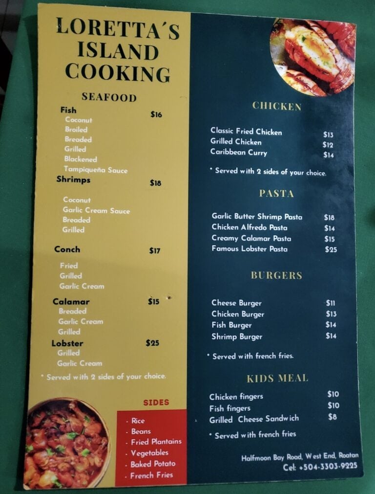 A colorful laminated menu from Loretta's Island Cooking in Roatan, Honduras, displays various seafood, chicken, pasta, burger, and kids' meal options with prices, along with side dishes listed at the bottom and a small image of cooked seafood in the top right corner.