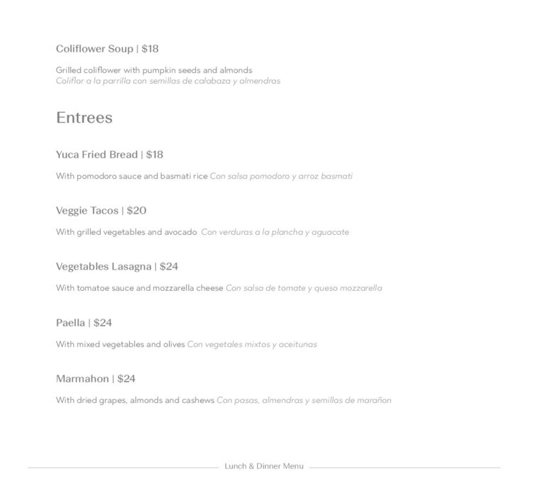 A printed lunch and dinner menu from a restaurant in Roatan, Bay Islands, Honduras, displaying various dishes such as cauliflower soup, yuca fried bread, veggie tacos, vegetables lasagna, paella, and marmahon, with prices listed for each item.