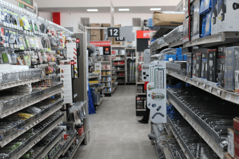 A hardware store aisle filled with shelves stocked with tools, hardware supplies, and electrical accessories in Roatan, Honduras.