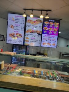 A buffet station with various toppings and condiments, situated in a restaurant or food establishment in Roatan, Honduras.