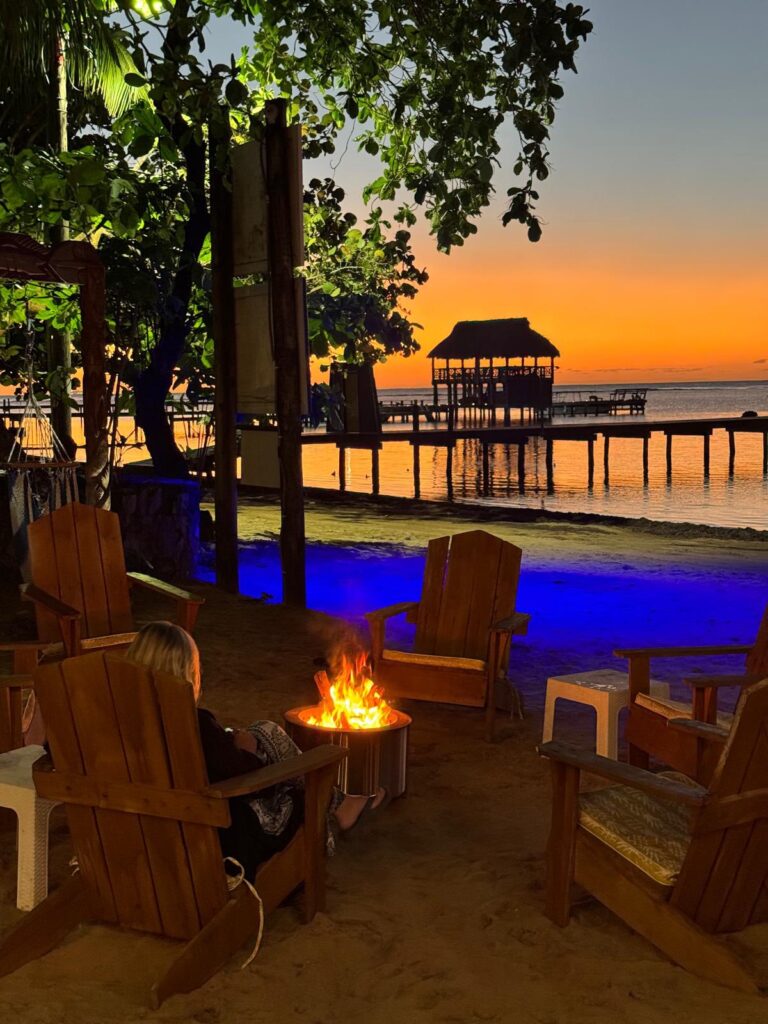 Sunset view with fire pit and ocean, perfect for movie night.
