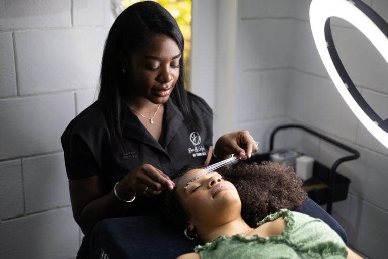 Beauty professional performing a skincare treatment on a client.