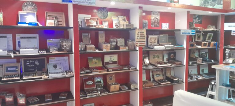Cigar and liquor storefront display on Roatan in Honduras featuring shelves with cigars, whiskey bottles, and promotional displays in a vibrant interior setting.