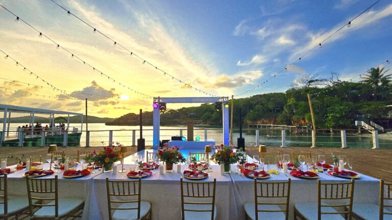 Elegant waterfront dining setup with sunset view in Roatan, Honduras. Perfect for romantic evenings.