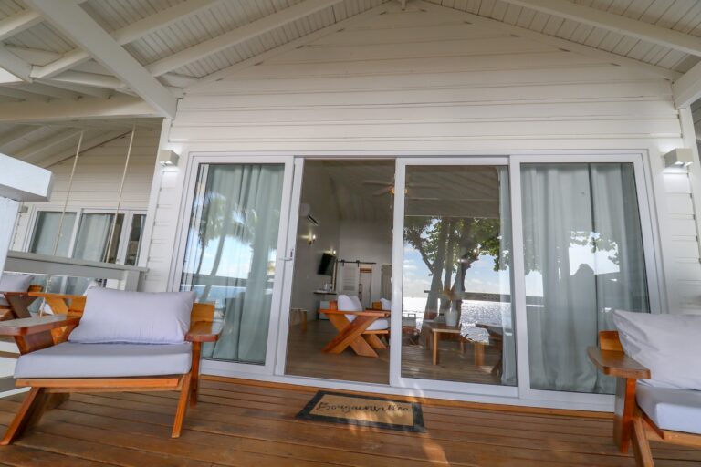 Beachfront bungalow with sliding glass doors and outdoor seating at Luna Beach Resort.