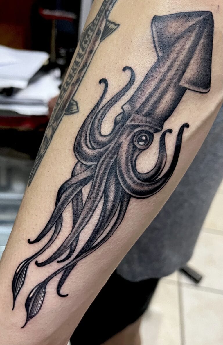 Detailed squid tattoo with flowing tentacles displayed on a person's forearm in Roatan, Honduras.