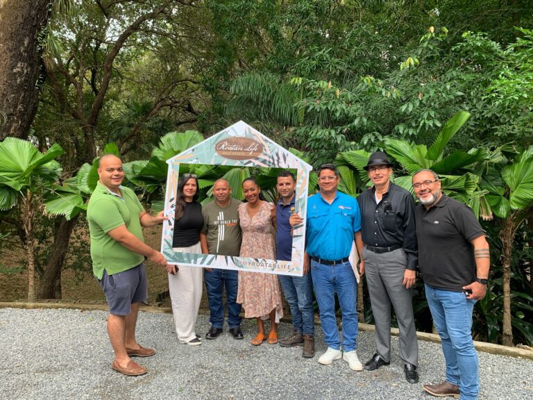 Group of people holding a photo frame at Roatan Life Real Estate event.