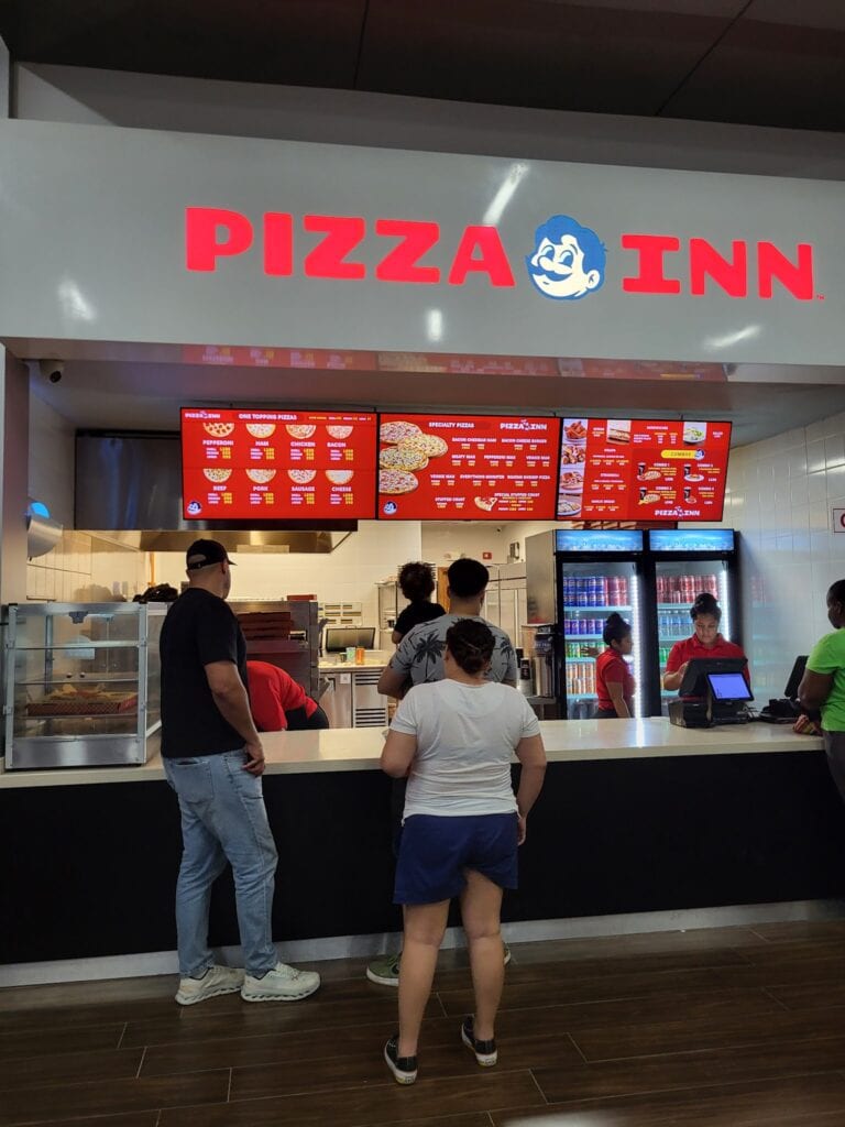 Customers place their orders at the counter of a Pizza Inn restaurant inside a shopping mall on Roatan, Bay Islands, Honduras.