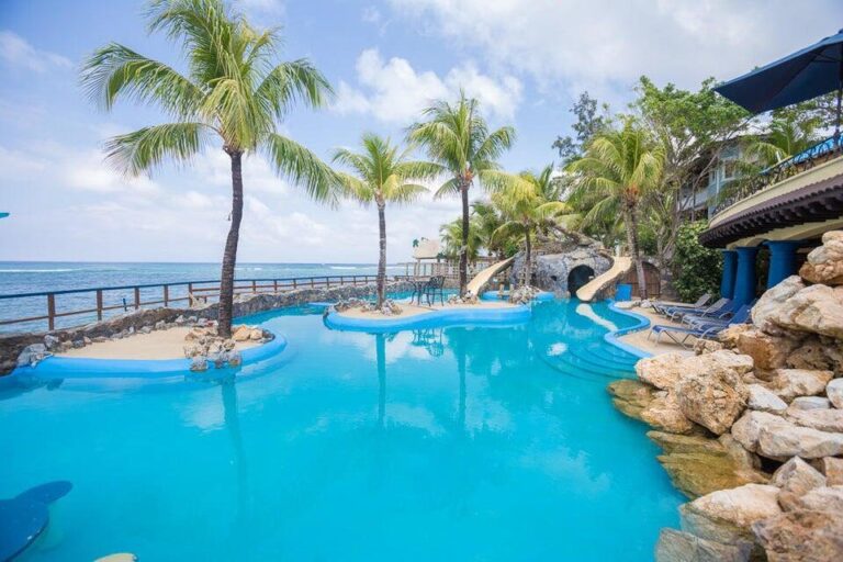Pool area with palm trees overlooking the ocean on Roatan in the Bay Islands of Honduras.