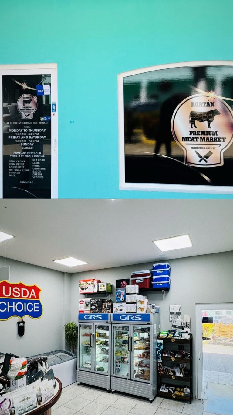 The image shows the interior of a meat market in Roatan, Honduras, with refrigerated display cases filled with various meat products, a wall-mounted USDA Choice sign, and shelves stocked with coolers and other supplies.