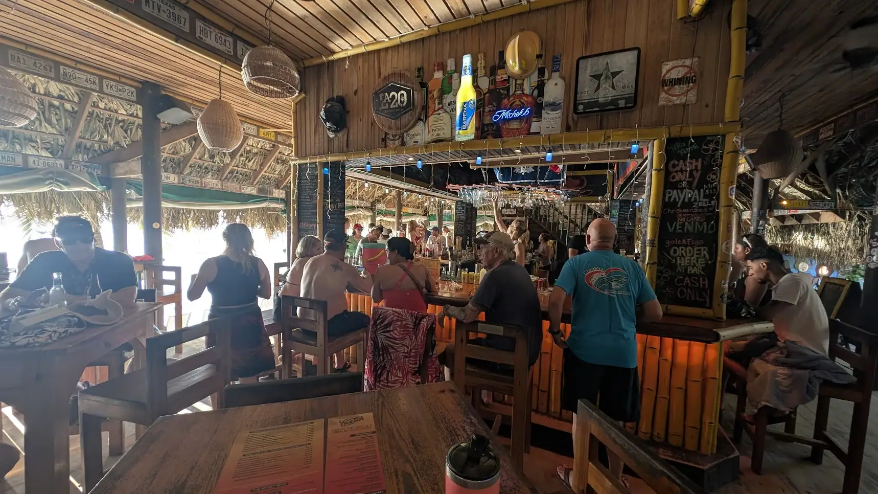 Open-air interior of Sundowners Beach Bar in West End Roatan looking toward the bar