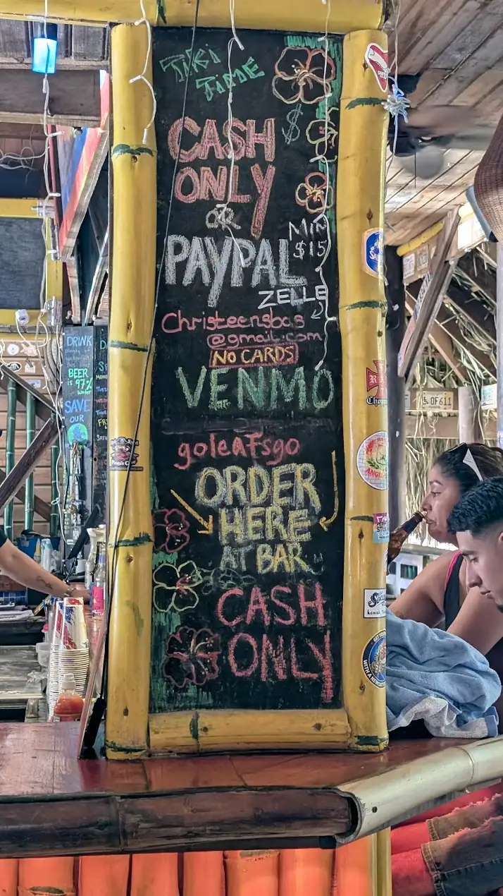 Payment and order board inside Sundowners Beach Bar West End Roatan showing cash and digital payment options