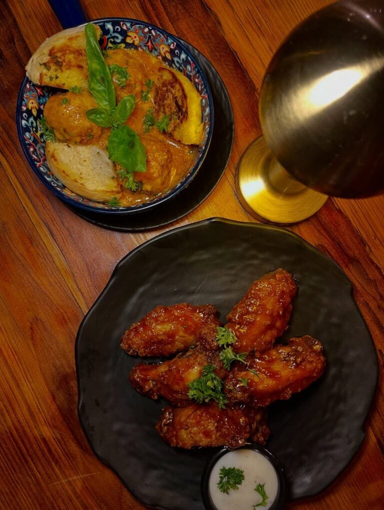 Delicious fried chicken wings with herbs served with a side of creamy dipping sauce.