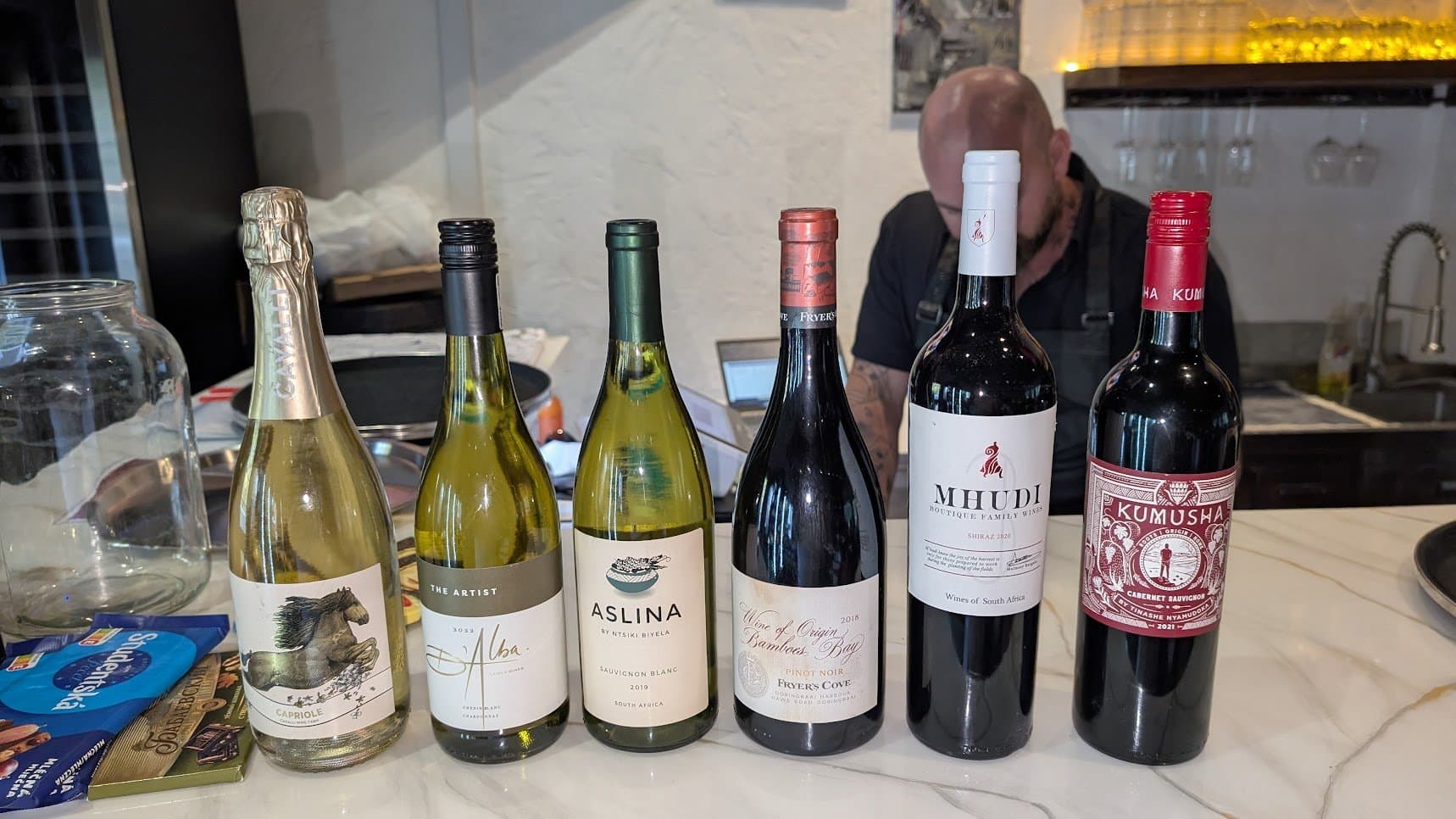 Six South African wines lined up for the Wine Not African Safari wine tasting in French Harbour Roatan including Cavalli Capriole D'Alba Aslina Fryer's Cove Mhudi and Kumusha