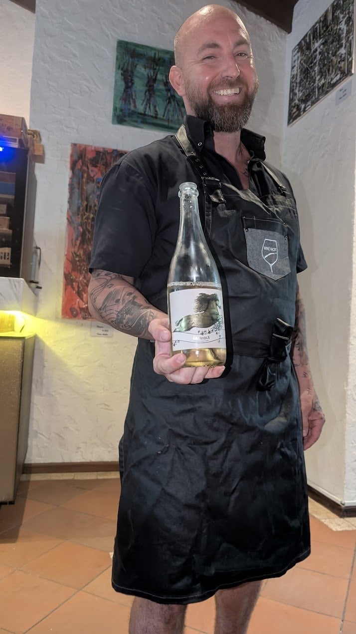 Martin wine enthusiast at Wine Not Roatan holding the Cavalli Capriole MCC sparkling wine at the African Safari tasting in French Harbour