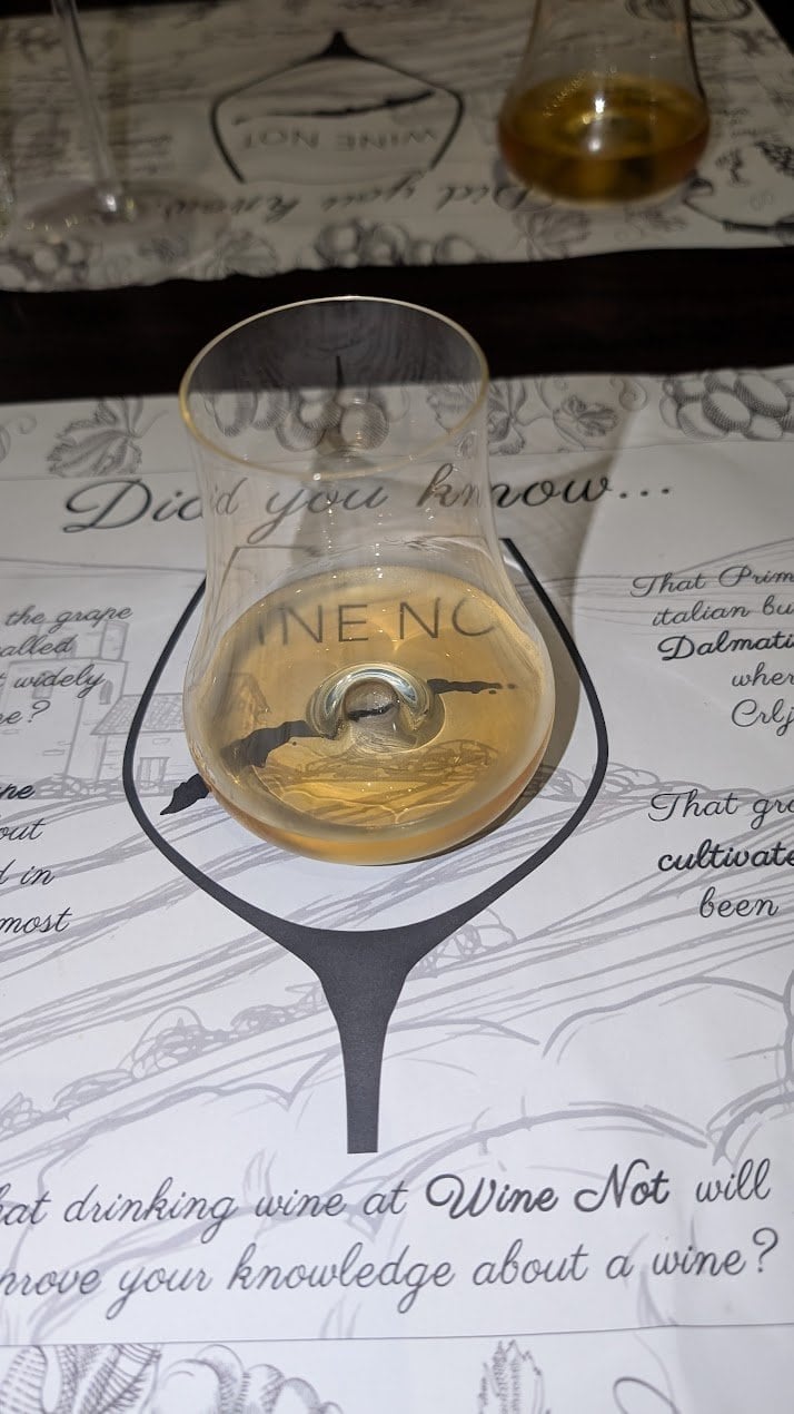 Wine Not Roatan branded tasting glass resting on the Wine Not tasting mat during the African Safari wine tasting in French Harbour