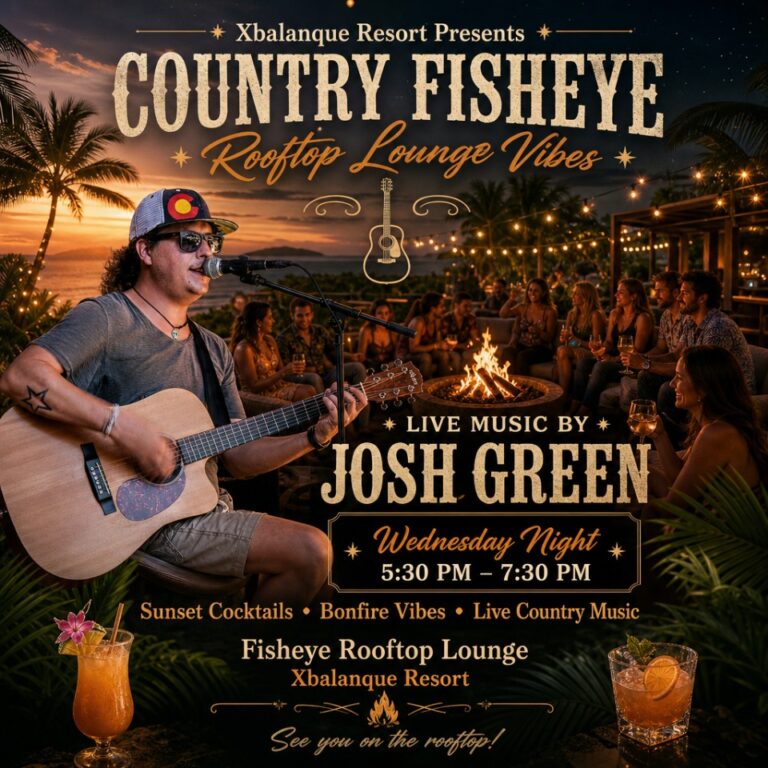 A male musician from Roatan, Honduras, performing with an acoustic guitar at the Fisheye Rooftop Lounge during sunset, with a lively audience around a bonfire.